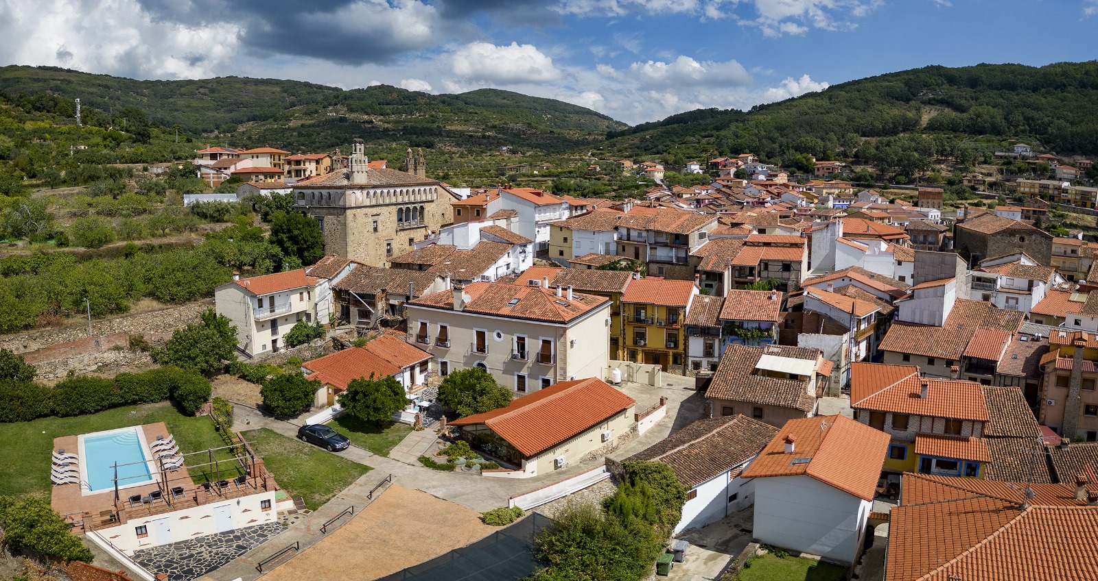 Vista aérea real de La Casa de Pasarón, su piscina y el pueblo de Pasarón de la Vera